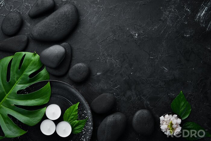 Canvas Zen stones and leaves with water drops. Spa background with spa accessories on a dark background. Top view. Free space for your text.
