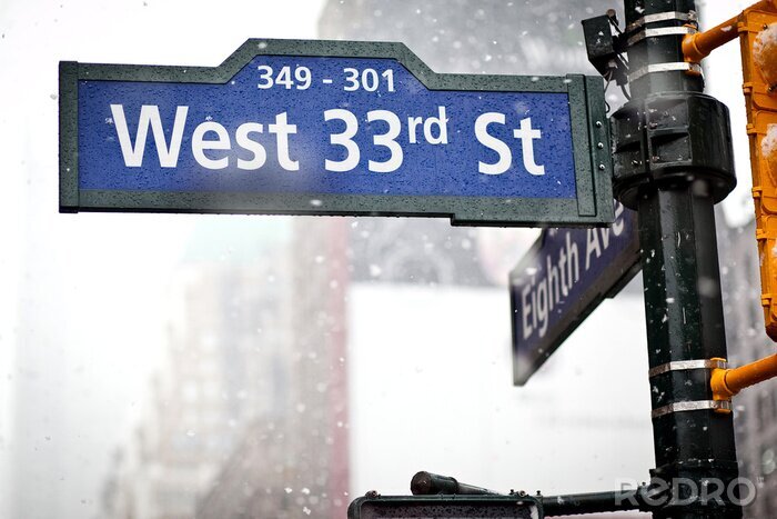 Fotobehang 33e straat richting teken in New York in sneeuwstorm