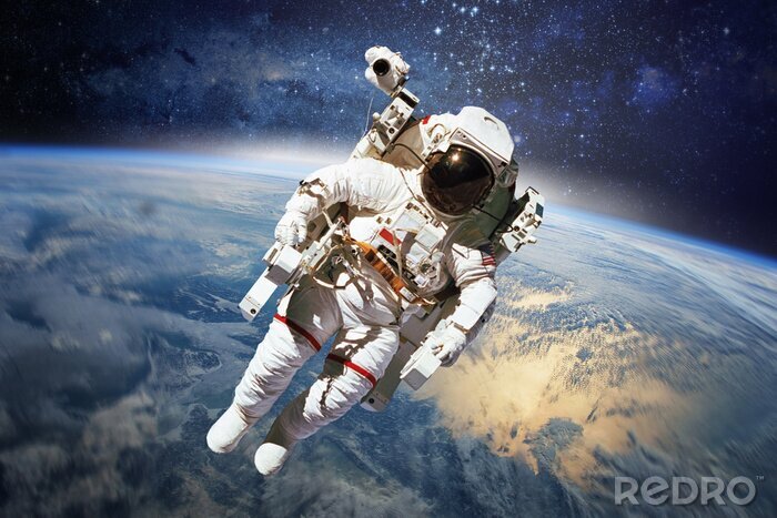 Fotobehang Astronaut in het heelal met de aarde op de achtergrond