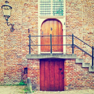 Fotobehang Baksteen architectuur met rode deuren