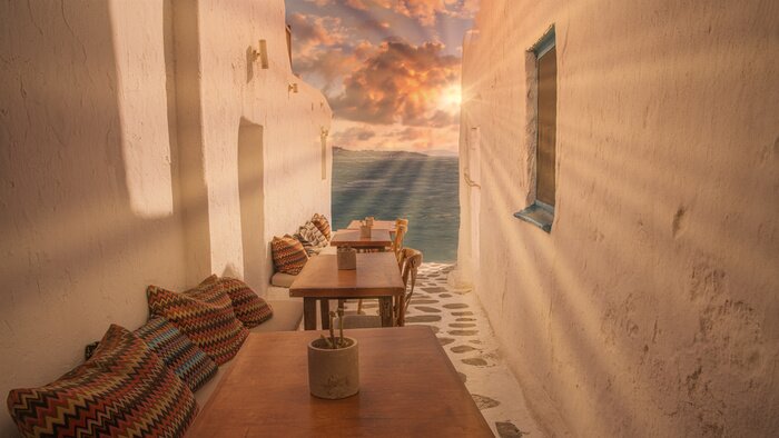 Fotobehang Benches with pillows in a typical Greek bar in Mykonos town with sea view, Cyclades islands, Greece. Travel concept.