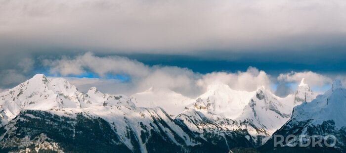 Fotobehang Bergen in sneeuw en donkere wolken