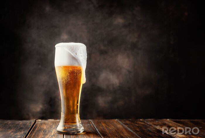 Fotobehang Bier in een glas op een grijze achtergrond