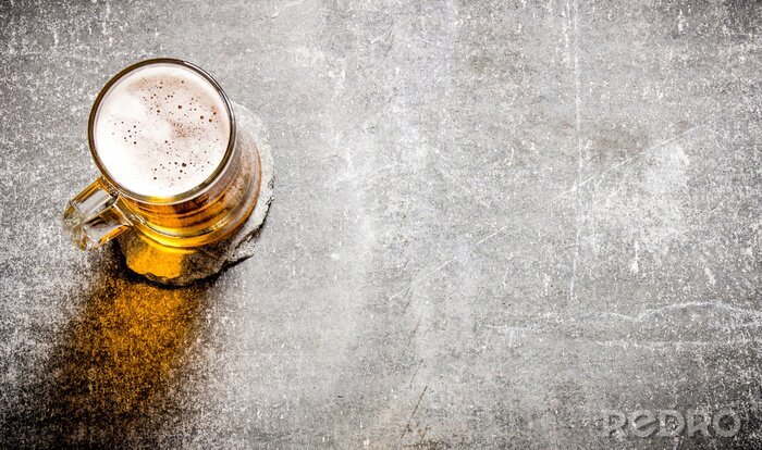 Fotobehang Bier in een glas op oude stenen oppervlak.