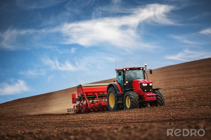 Fotobehang Boer met tractor zaaien gewassen op het veld