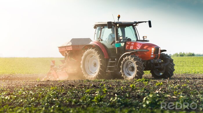 Fotobehang Boer met zaaimachine - in de lente zaaien gewassen op landbouwgebied