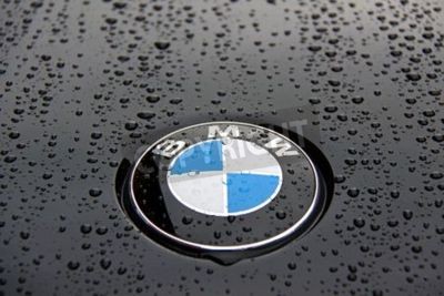 Fotobehang Bonnet en kenteken van een zwarte BMW 1-serie met regen druppels