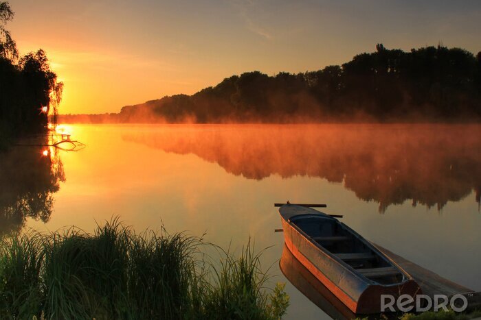 Fotobehang Boot op de oever van een mistige meer