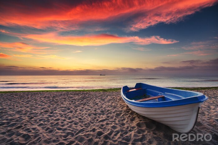 Fotobehang Boot op het strand bij zonsondergang
