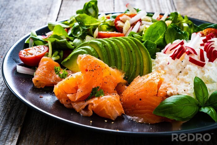 Fotobehang Breakfast - smoked salmon, cottage cheese, avocado and vegetable salad on wooden table