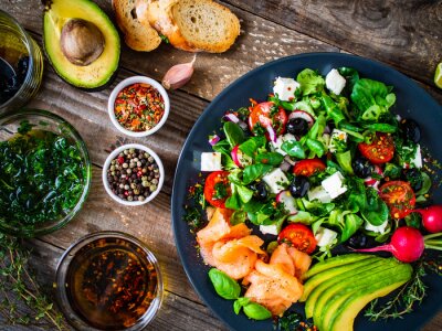 Fotobehang Breakfast - smoked salmon, feta cheese, avocado and vegetable salad on wooden table 