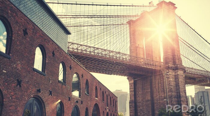 Fotobehang Brooklyn Bridge bij zonsondergang met lens flare, kleur toning toegepast, New York City, USA.