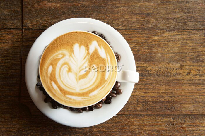 Fotobehang caramel latte en koffie bonen op houten tafel