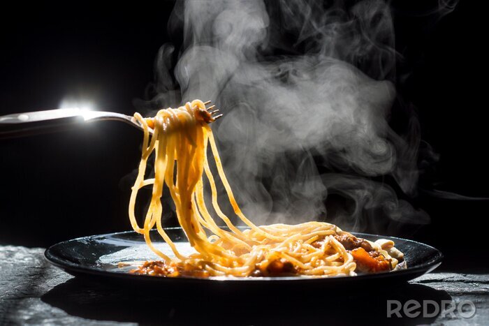 Fotobehang De stoom van spaghetti met tomatensaus - zelfgemaakte gezonde Italiaanse pasta op donkere achtergrond