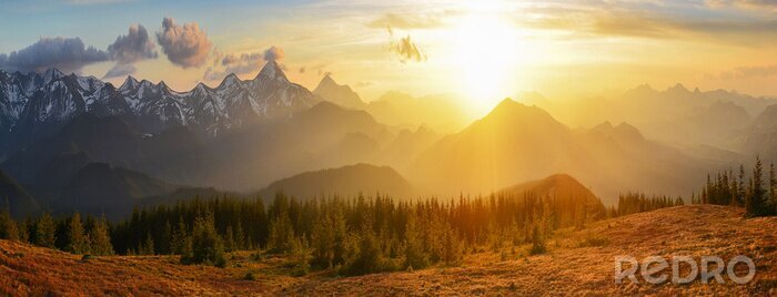 Fotobehang De zon die ondergaat achter de bergen