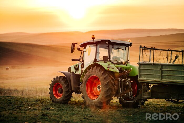 Fotobehang Details van landbouwer die op de gebieden met tractor aan een zonsondergangachtergrond werkt. Landbouw industrie details