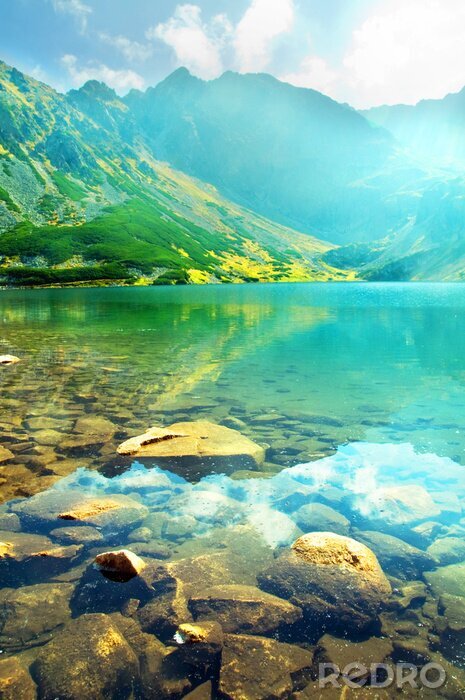 Fotobehang Doorzichtig water en bergen