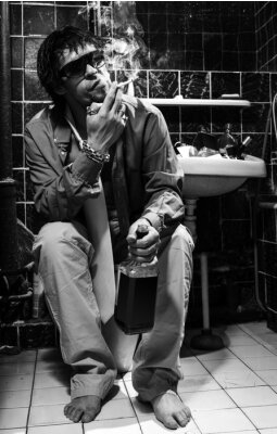 Fotobehang Dronken man zit in een toilet met een alcohol fles