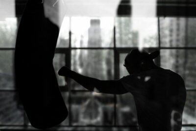 Fotobehang Een bokser die op een bokszak slaat