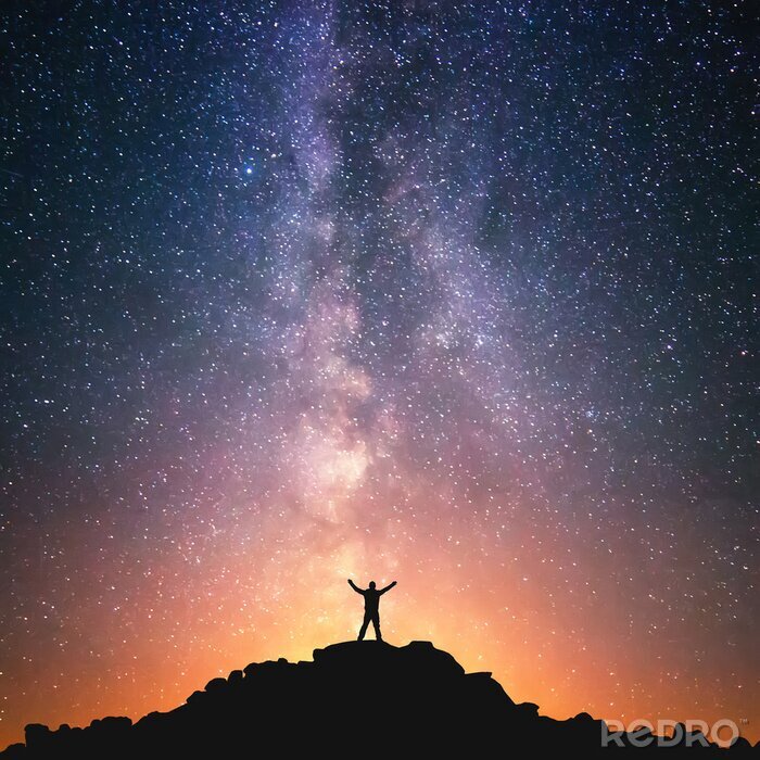 Fotobehang Een hemel vol sterren en het silhouet van een man op de top