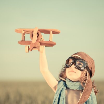 Fotobehang Een kind met een speelgoedvliegtuig