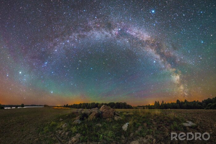 Fotobehang Een kleurrijk sterrenstelsel boven de horizon