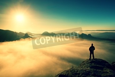 Fotobehang Een man en de zonsopgang boven de wolken