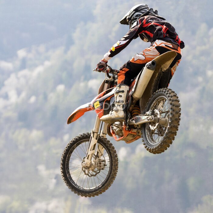 Fotobehang Een motorrijder die een motorcrosssprong maakt