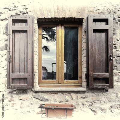 Fotobehang Een raam met luiken in een stenen huis