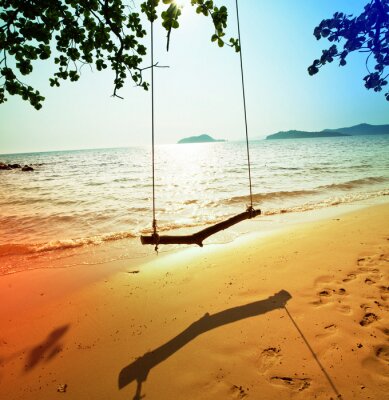 Fotobehang Een schommel op een leeg strand