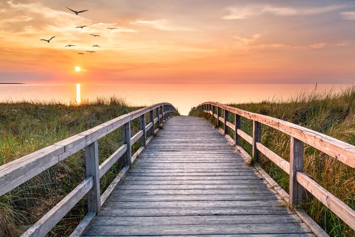 Fotobehang Een steiger over de zee in het licht van de zonsopgang