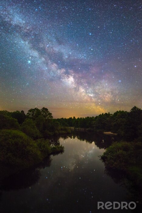 Fotobehang Een sterrenstelsel dat reflecteert in de wateren van een meer