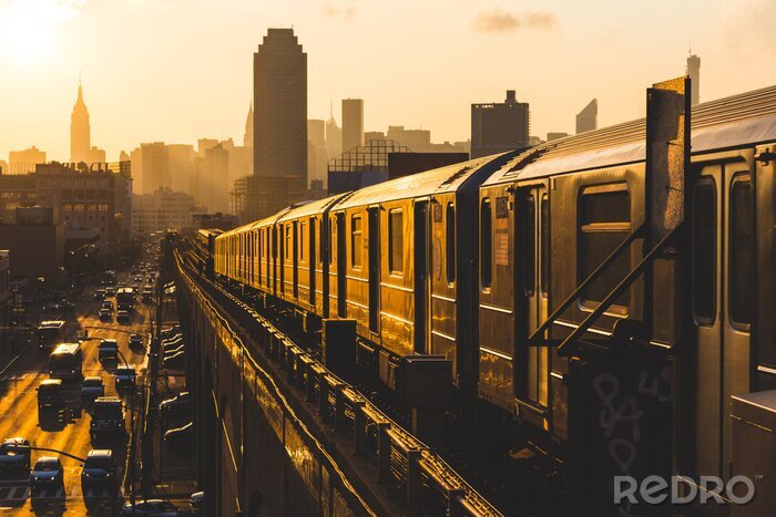 Fotobehang Een trein die bij zonsondergang door New York rijdt