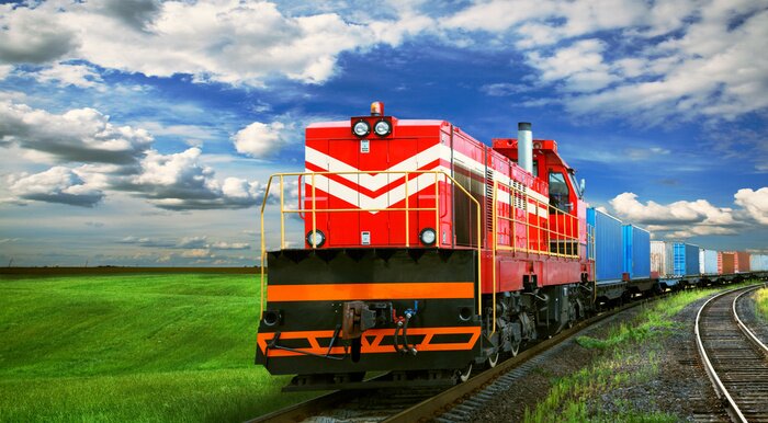 Fotobehang Een trein met een weide op de achtergrond