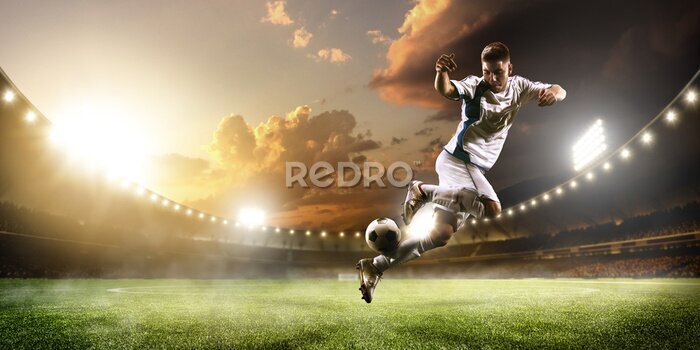 Fotobehang Een voetballer die de bal in het stadion schopt