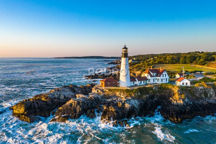 Fotobehang Een vuurtoren op een rots tegen een wolkenloze hemel