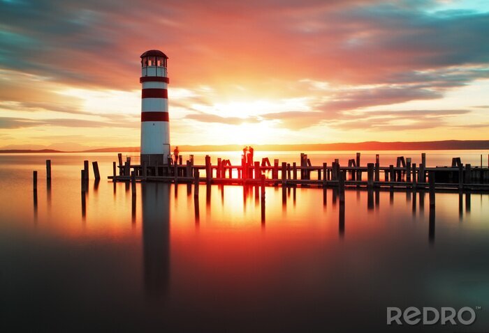 Fotobehang Een vuurtoren tegen de achtergrond van de opkomende zon