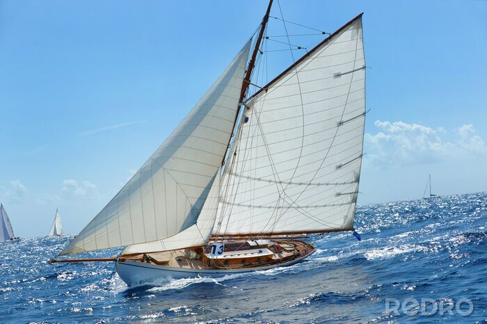 Fotobehang Een zeiljacht vaart op een kalme zee.