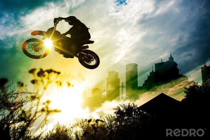 Fotobehang Evolutie op een motorfiets tegen de achtergrond van de ondergaande zon.