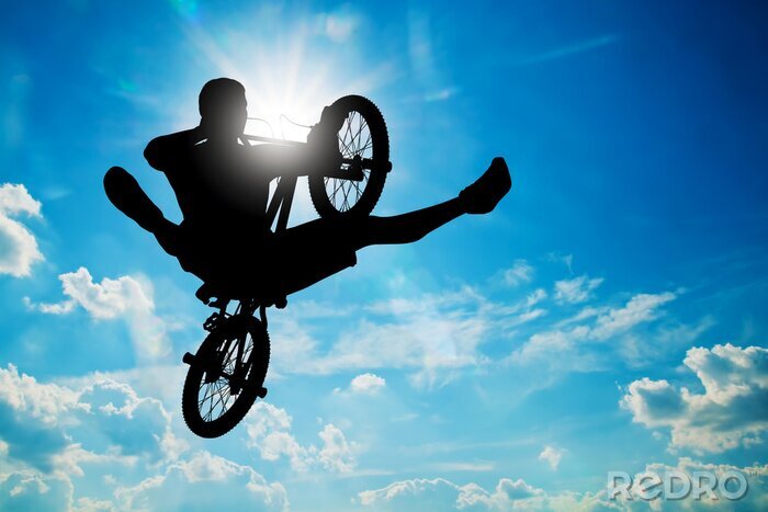 Fotobehang Fietser met fiets tegen een hemelachtergrond