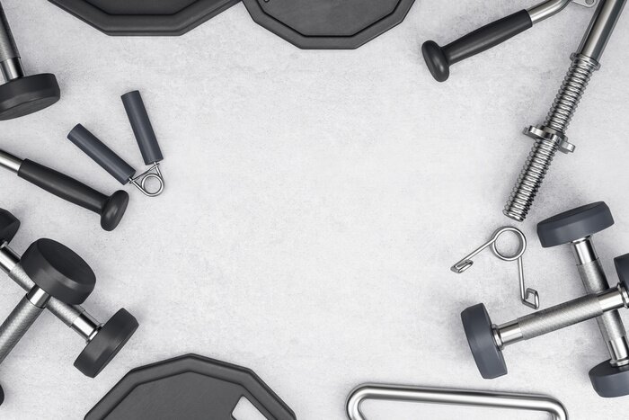 Fotobehang Fitnessapparaten op betonnen achtergrond