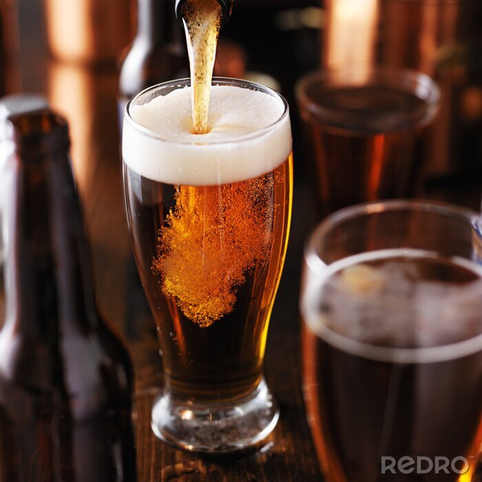 Fotobehang gieten bier in glas op houten tafel