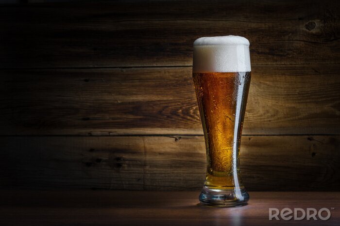 Fotobehang Glas bier tegen een achtergrond van hout