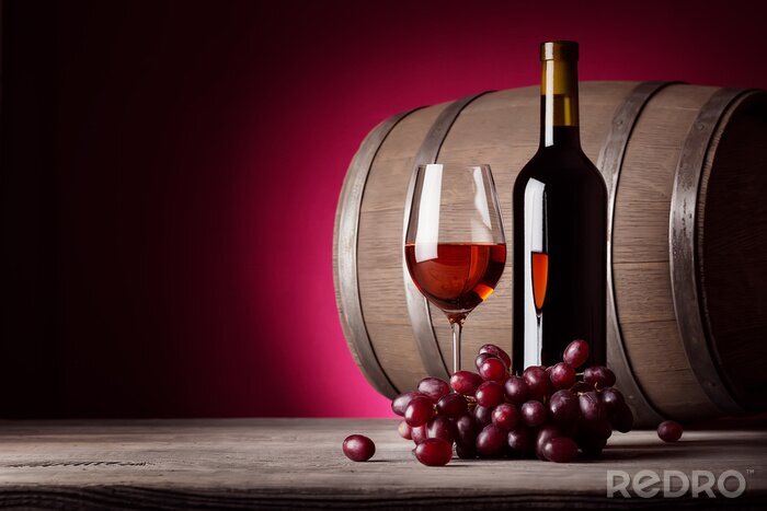 Fotobehang Glas rode wijn met fles en druiven