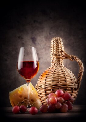 Glas rode wijn met karaf en druiven