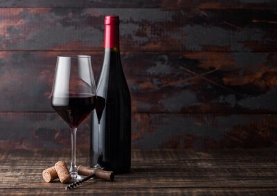 Fotobehang Glas wijn en fles op een houten achtergrond
