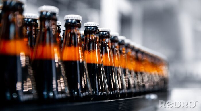 Fotobehang Glass bottles of beer on dark background with sun light. Concept brewery plant production line