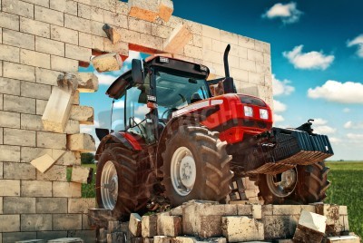 Fotobehang Gloednieuw Tractor, krachtige agrarische werkende machine doorbreken van de muur. Het overwinnen van alle obstakels in de landbouw en de landbouw productie.