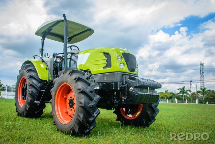 Fotobehang gloednieuwe tractor op het gras, klaar om te werken