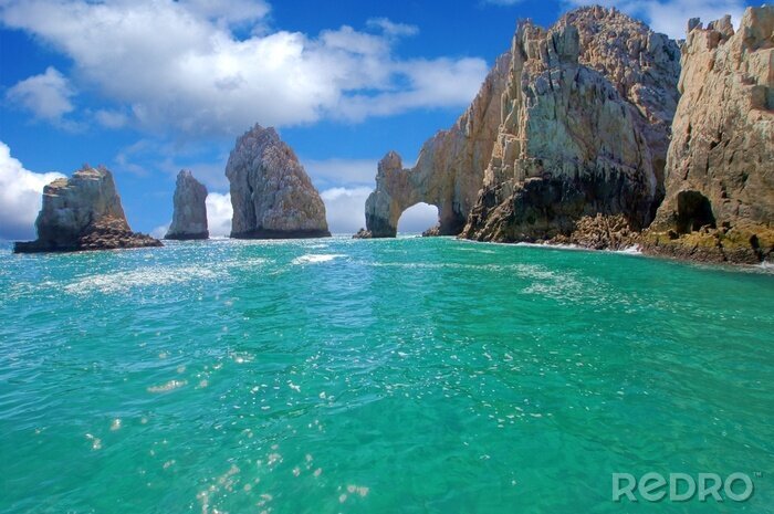 Fotobehang Grijze rotsen en turquoise water